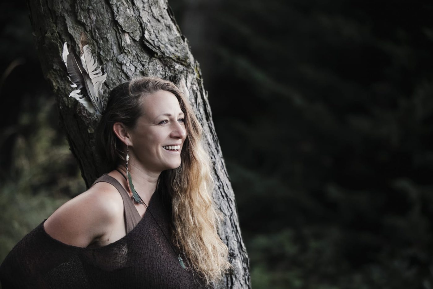 Linda Arent lacht, an einen Baum gelehnt